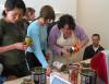 Suzi Pritchett and Meg Duguid working as a team to empower an old coffee can.